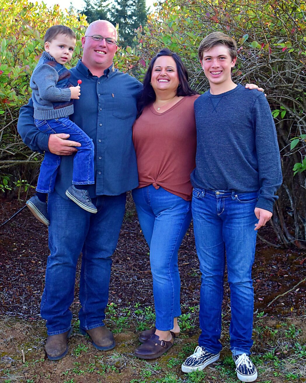 Parents smiling between two sons outdoors